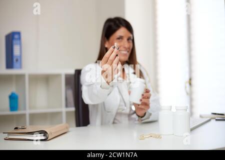 femme médecin montrant des pilules Banque D'Images
