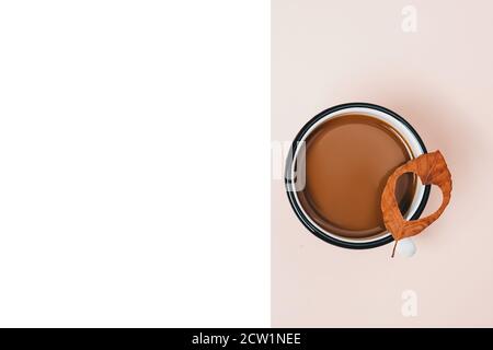 Automne, jour d'action de grâce et concept d'hiver. Café de tasse et feuilles séchées de forme de coeur sur fond beige et blanc studio avec espace de copie pour adver Banque D'Images