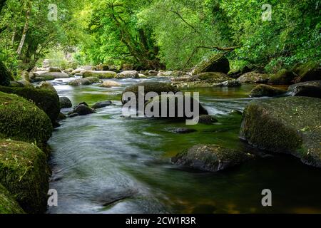 Ruisseau de montagne qui coule sur et autour des blocs de granit Banque D'Images