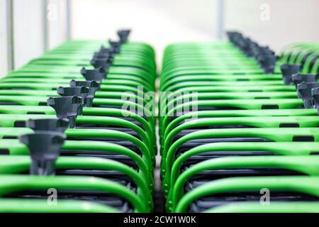 Des lignes de chariots à l'extérieur du supermarché. Les chariots verts sont regroupés en une ligne. Banque D'Images