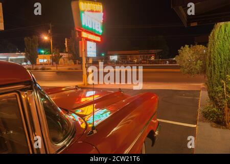 Albuquerque États-Unis septembre 17 2015 ; les feux de signalisation se reflètent dans le capot de voiture rouge à l'extérieur du motel Monterey sous le panneau néon sur la route 66, Nouveau-Mexique, États-Unis. Banque D'Images