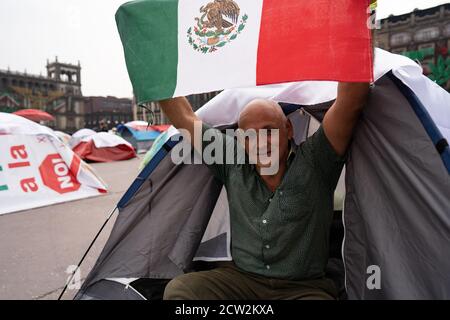 Mexico, Mexique. 26 septembre 2020. Un manifestant Frena tient un drapeau mexicain de l'intérieur de sa tente. Des centaines de personnes ont campé dans des tentes dans le Zocalo dans le cadre d'une campagne pour démettre le président mexicain, Andres Manuel Lopez Obredor. Dans le même temps, des milliers de personnes ont protesté dans l'autre moitié du Zocalo pour marquer le 6e anniversaire de la date à laquelle les 43 étudiants ont disparu d'Ayotzinapa. Credit: Lexie Harrison-Cripps/Alamy Live News Banque D'Images