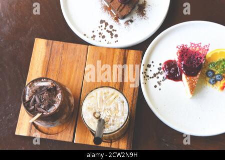 Chocolat à boire et thé au lait ou thé au lait de Taïwan en verre sur la table en bois avec gâteau, vue du dessus Banque D'Images