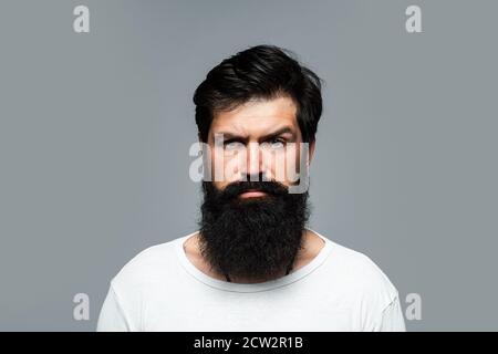 Portrait de l'homme sérieux confiant a la barbe et la moustache, regarde sérieusement, isolé. Modèles Hipster Guy en studio. Homme d'affaires pensant avec Banque D'Images