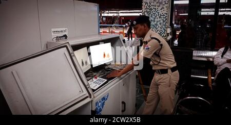 DISTRICT JABALPUR, INDE - 07 AOÛT 2019 : un policier indien inspecte des bagages sur écran de contrôle à la porte d'entrée de la gare. Banque D'Images