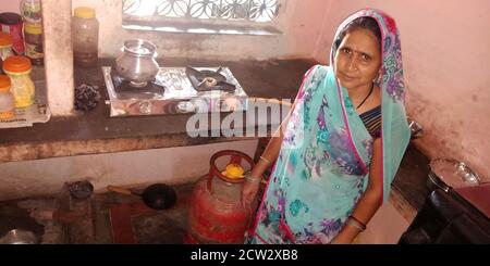 DISTRICT KATNI, INDE - 17 SEPTEMBRE 2019 : une pauvre dame d'un village indien présentant une bouteille de gaz pour ujjwala yojana. Banque D'Images