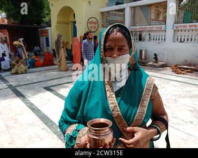 DISTRICT KATNI, INDE - 08 JUILLET 2020: Femme traditionnelle indienne portant un masque de protection contre le coronavirus dans un lieu religieux hindou pendant son voyage. Banque D'Images