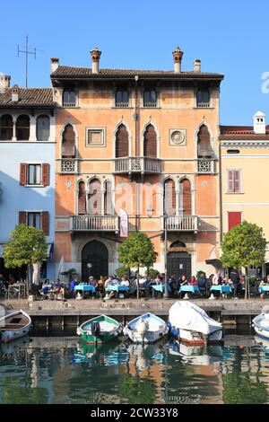 La vue sur les bateaux amarrés dans la station balnéaire de Desenzano aux cafés et restaurants. Desenzano est à la limite du lac de Garde dans le nord-est de l'Italie. Banque D'Images