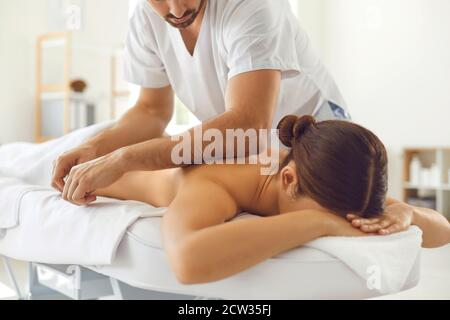 Masseuse professionnelle effectuant un massage corporel pour une jeune femme allongée table de massage Banque D'Images