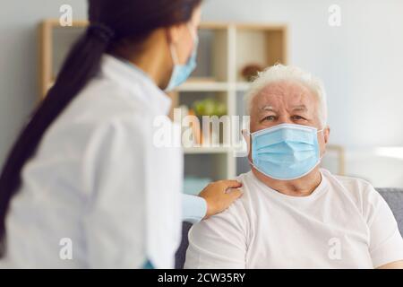 Une femme médecin rend visite à l'homme âgé et lui fournit un soutien pendant la quarantaine. Banque D'Images