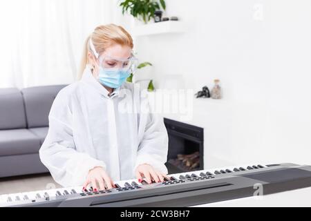 femme médecin dans un masque de protection joue le piano Banque D'Images