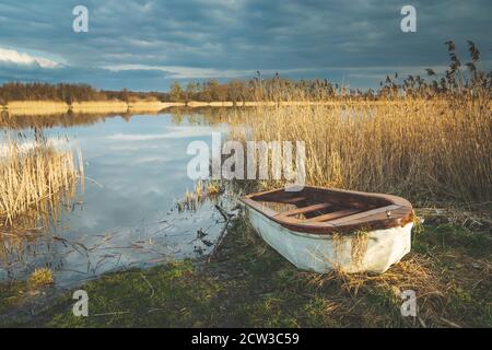 Un petit bateau sur la rive d'un lac Banque D'Images