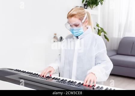 femme médecin dans un masque de protection joue le piano Banque D'Images