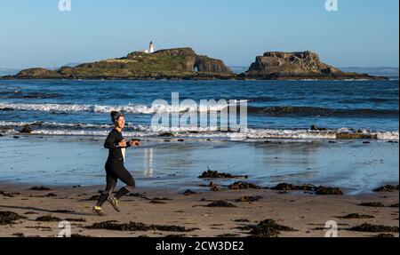 East Lothian, Écosse, Royaume-Uni, 27 septembre 2020. Scurry Running Event : les coureurs participent à un événement de course amusant de la plage de Yellowcraig à North Berwick et de retour sur une belle matinée ensoleillée d'automne. Fidra Island est à l'arrière-plan, tandis qu'une femelle court sur la plage Banque D'Images