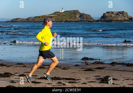 East Lothian, Écosse, Royaume-Uni, 27 septembre 2020. Scurry Running Event : les coureurs participent à un événement de course amusant de la plage de Yellowcraig à North Berwick et de retour sur une belle matinée ensoleillée d'automne. Fidra Island est à l'arrière-plan tandis qu'un coureur court sur la plage Banque D'Images