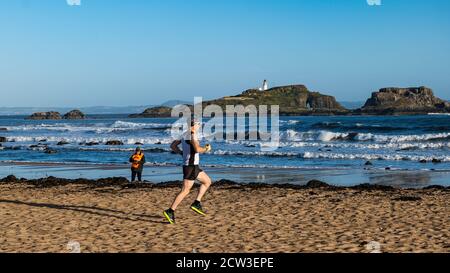 East Lothian, Écosse, Royaume-Uni, 27 septembre 2020. Scurry Running Event : les coureurs participent à un événement de course amusant de la plage de Yellowcraig à North Berwick et de retour sur une belle matinée ensoleillée d'automne. Fidra Island est en arrière-plan, tandis qu'un coureur amle court sur la plage Banque D'Images