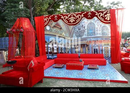 Canapés rouges joliment décorés ou canapé prêt pour les invités assis dans un lieu de cérémonie d'engagement dans l'arrière-cour, concept de décoration d'événement de mariage Banque D'Images