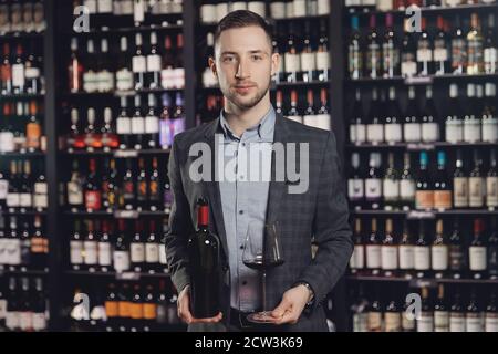 L'homme verse du vin dans un élégant gobelet en verre de la bouteille Banque D'Images