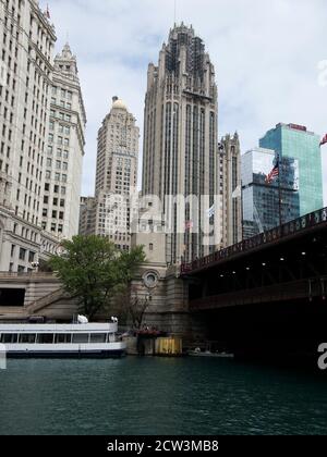 Un bateau d'excursion amarré sur la rivière Chicago à côté du pont Dusable à Chicago, Illinois, avec des bâtiments historiques derrière Banque D'Images