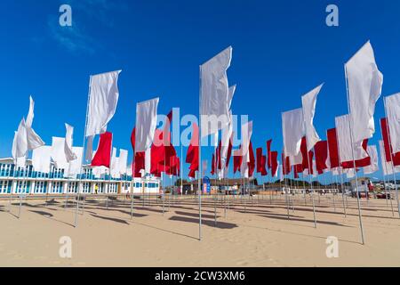 Sandbanks, Poole, Dorset Royaume-Uni. 27 septembre 2020. Les gens visitent l'œuvre de Luke Jerram « In Memoriam » sur la plage de Sandbanks, créée à partir de plus de 100 draps, une mer géante de drapeaux pour se souvenir de ceux perdus avec Covid-19, qui fait partie du festival des arts de Bournemouth by the Sea. Organisée sous la forme d'un logo médical, d'une croix rouge sur fond blanc, l'installation rend également hommage aux membres courageux du personnel du NHS et aux bénévoles qui continuent de risquer leur vie pour soigner les milliers de personnes touchées par le coronavirus. Crédit : Carolyn Jenkins/Alay Live News Banque D'Images