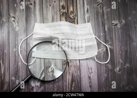 Concept Covid-19, masque facial et loupe Banque D'Images