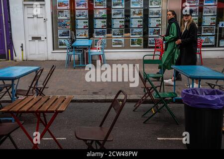 Londres, Royaume-Uni. 27 septembre 2020. Marchés contrastés - les agents immobiliers offrent de l'aide pour se déplacer dans le pays tandis que les tables de bar restent vides - le dernier jour de la fermeture de la route pour manger et boire en plein air et à l'heure de pointe pour le déjeuner du dimanche, mais la plupart des établissements sont vides. Un double caprice pour le secteur des loisirs, alors que le temps anormalement chaud disparaît, à l’arrivée de l’automne, et que le gouvernement apporte des contrôles plus stricts en réponse à l’augmentation des cas Covid 19. Des moments difficiles pour les restaurants et les bars de Northcote Road, Battersea/Clapham. Crédit : Guy Bell/Alay Live News Banque D'Images