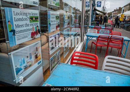 Londres, Royaume-Uni. 27 septembre 2020. Marchés contrastés - les agents immobiliers offrent de l'aide pour se déplacer dans le pays tandis que les tables de bar restent vides - le dernier jour de la fermeture de la route pour manger et boire en plein air et à l'heure de pointe pour le déjeuner du dimanche, mais la plupart des établissements sont vides. Un double caprice pour le secteur des loisirs, alors que le temps anormalement chaud disparaît, à l’arrivée de l’automne, et que le gouvernement apporte des contrôles plus stricts en réponse à l’augmentation des cas Covid 19. Des moments difficiles pour les restaurants et les bars de Northcote Road, Battersea/Clapham. Crédit : Guy Bell/Alay Live News Banque D'Images