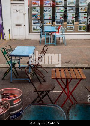 Londres, Royaume-Uni. 27 septembre 2020. Marchés contrastés - les agents immobiliers offrent de l'aide pour se déplacer dans le pays tandis que les tables de bar restent vides - le dernier jour de la fermeture de la route pour manger et boire en plein air et à l'heure de pointe pour le déjeuner du dimanche, mais la plupart des établissements sont vides. Un double caprice pour le secteur des loisirs, alors que le temps anormalement chaud disparaît, à l’arrivée de l’automne, et que le gouvernement apporte des contrôles plus stricts en réponse à l’augmentation des cas Covid 19. Des moments difficiles pour les restaurants et les bars de Northcote Road, Battersea/Clapham. Crédit : Guy Bell/Alay Live News Banque D'Images