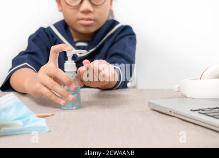 Fille asiatique utilisant le distributeur de gel désinfectant pour les mains de lavage, se laver la main avec de l'alcool désinfectant, prévenir le virus et les bactérias, hygiène et Covid-19 vi Banque D'Images