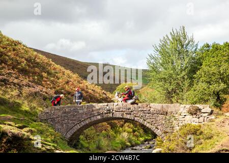 Motocyclistes tout-terrain utilisant un sentier vert traversant le Pont de pierre aux trois shires tête dans le pic Parc national du district Angleterre Royaume-Uni Banque D'Images