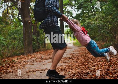 Bébé joue avec papa à l'extérieur en automne. Le père tient une petite fille mignonne dans ses bras. Portrait d'automne d'un enfant. Famille heureuse et moments d'enfance. Banque D'Images