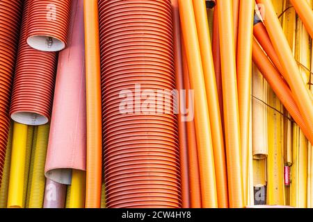 Tuyaux en plastique en noir, rouge, orange et jaune. Banque D'Images
