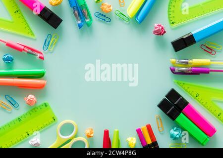 articles d'école et de bureau, stylos de couleur, agrafes, marqueurs, carrés de mise en place, sur un verre pastel. Espace vide pour le texte. Banque D'Images