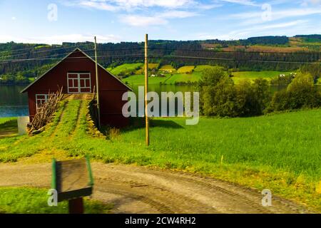 Grange rouge sur la rive du lac de Slidrefjord, Kvåle village Innlandet County in Norvège orientale.Tyinvegen, Norvège vue de E16-route européenne de Bergen à Oslo Banque D'Images