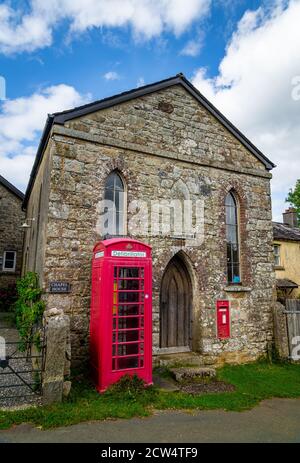 Ancienne chapelle et édifice télégraphique avec boîte postale et téléphone kiosque dans le petit village de Dartmoor Banque D'Images