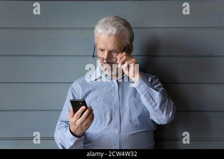 Un homme adulte choqué surpris par un message de cellule inattendu Banque D'Images