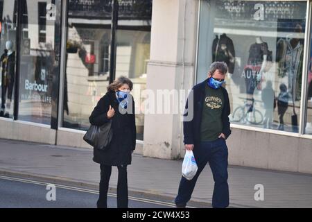 Une femme et un homme âgés marchent le long de la Parade, Leamington Spa, tout en portant des revêtements de visage assortis Banque D'Images