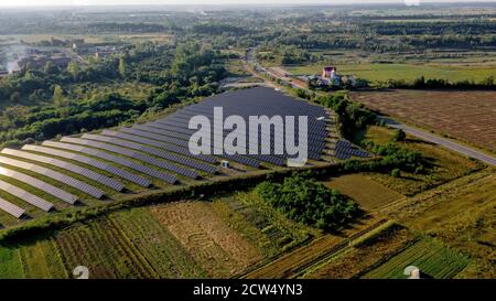 Station d'énergie solaire à Green Field le Sunny Day. Vue aérienne. Panneaux solaires dans une rangée sur le terrain pour la production d'énergie. Un drone survole Solar Farm Banque D'Images