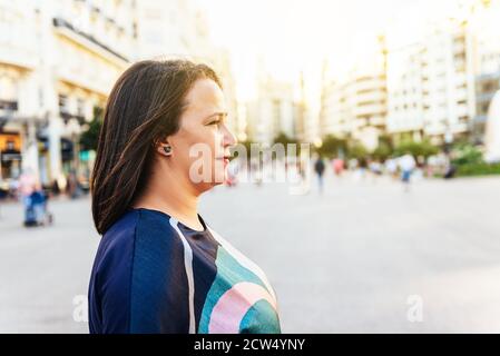 Femme brune d'âge moyen face latérale dans une place en Europe au coucher du soleil. Espace de copie Banque D'Images