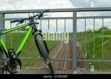 Bicycle se trouve sur le pont au-dessus du chemin de fer, vue de dessus. Concept du tourisme Banque D'Images