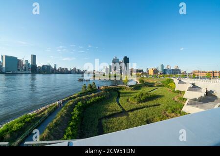 Vue sur le gratte-ciel de Lower Manhattan au-delà de l'East River, qui se dresse au-delà du vert frais le long du sentier dans le parc national de Gantry Plaza à Que Banque D'Images