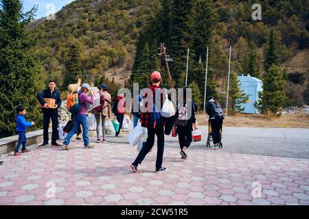 Les touristes se préparent pour une randonnée dans les montagnes.Groupe de personnes avec des sacs et des sacs à dos vont pique-nique. Pins et sapins de montagne. Équipe sur la nature. Bichkek, Kirghizistan - 9 avril 2019. Banque D'Images