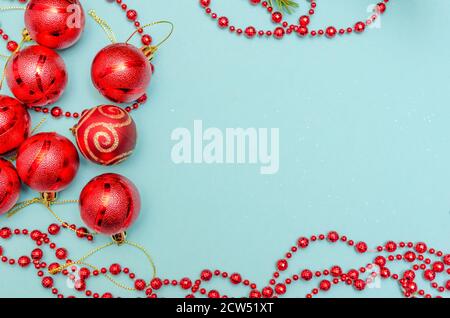 Perles de Noël rouges avec boules rouges sur fond bleu clair. Cadre de Noël. La vue du dessus. Copier l'espace Banque D'Images