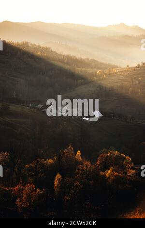 paysage d'automne idyllique tôt le matin au lever du soleil avec des couleurs vives Arbres et montagnes illuminées.Bucovina, Roumanie Banque D'Images
