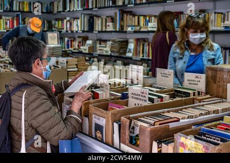 Un visiteur portant un masque facial comme mesure préventive cherche des livres utilisés.sous l'impact de la pandémie de Covid19, Barcelone célèbre sa 69e occasion de livre Foire, ancien et nouveau, dans l'enclave habituelle de Passeig de Gràcia mais avec des mesures anti-contagion. Banque D'Images