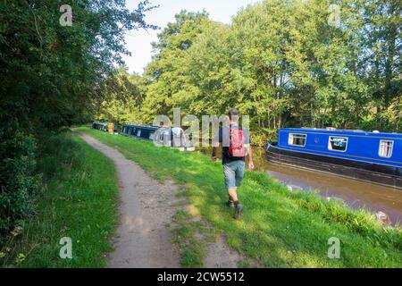 Homme randonneur marchant sur le sentier de randonnée de grès long chemin le long Le chemin de halage de la jonction du Shropshire canal Llangollen branche près Tout-en-un Banque D'Images