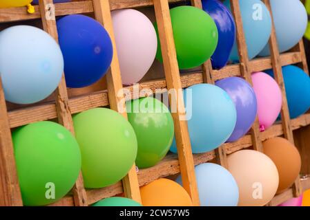 Ballons multicolores dans des cellules en bois. Arrière-plan des bulles de couleur Banque D'Images