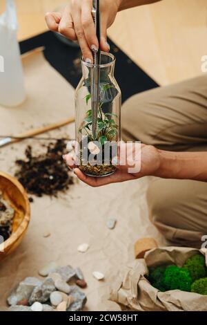 Les mains des femmes créent de la composition avec le jardin à l'intérieur de la bouteille en verre Banque D'Images