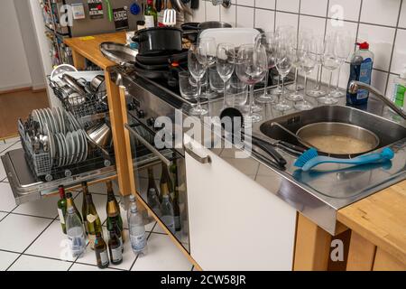 Cuisine après un dîner plus grand, partie de cuisine, lave-vaisselle, plein, avec vaisselle nettoyée, verres sales, casseroles, ustensiles de cuisine sur l'évier, en attente d'être Banque D'Images