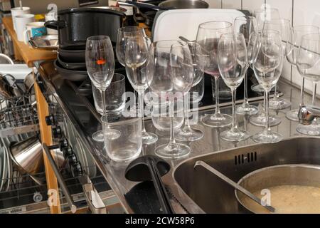 Cuisine après un dîner plus grand, partie de cuisine, lave-vaisselle, plein, avec vaisselle nettoyée, verres sales, casseroles, ustensiles de cuisine sur l'évier, en attente d'être Banque D'Images